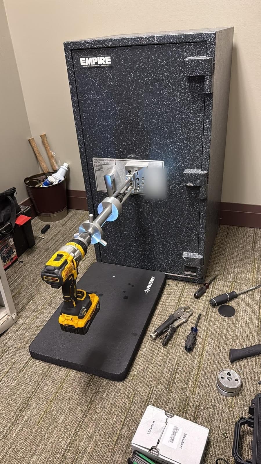 Drill rig set up on an Empire safe, tools on the floor