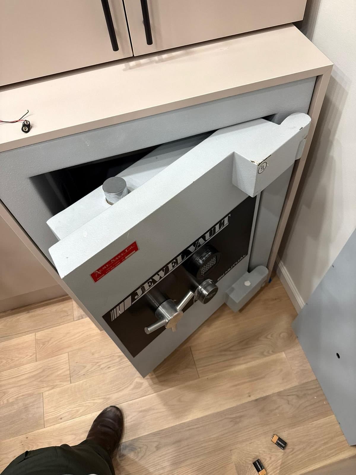 A Jewel Vault safe built into a cabinet, door open