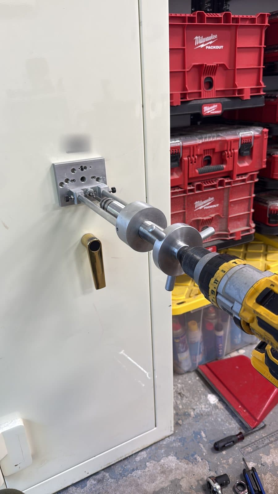 Drill rig mounted on a white safe door